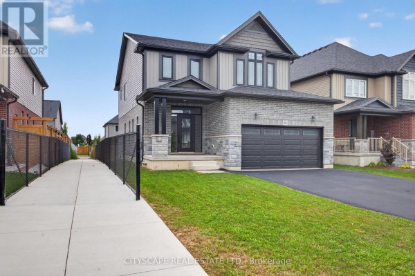Side view of the house with a paved walkway and fenced yard. - 68 Davidson Drive W, Stratford