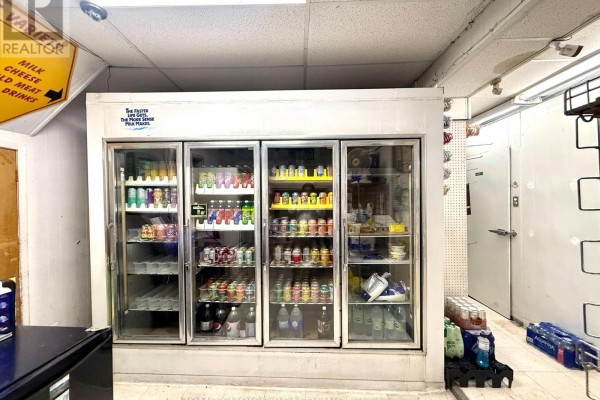 Four-door glass-fronted refrigerators are filled with various canned drinks. - 68 Dunlop Street W, Barrie
