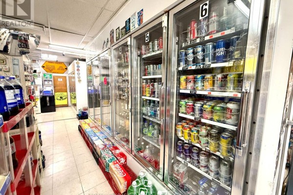 Multiple glass-fronted refrigerators display rows of canned beer and beverages. - 68 Dunlop Street W, Barrie