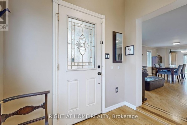 Interior front door with a stained glass insert and adjacent wall mirror. - 68 Eaglewood Boulevard E, Mississauga