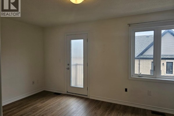 Interior hallway with wood floors, white doors, and stairs leading to double doors. - 68 First Street Unit# 34, Orangeville