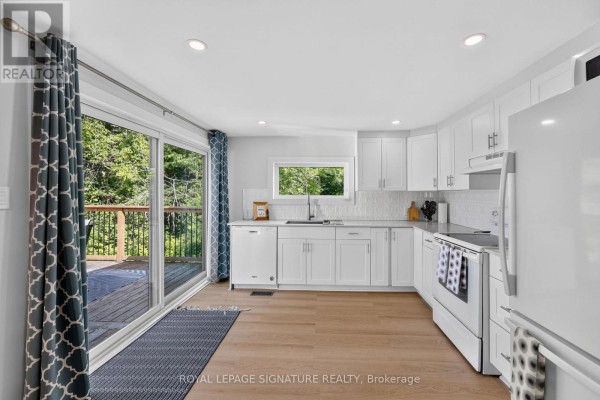 Covered porch with wooden decking, two chairs, and winter decorations. - 68 Forest Harbour Parkway, Tay