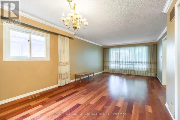 Living room featuring hardwood floors, beige walls, and a large window with patterned drapes. - 68 Fullerton Crescent, Markham