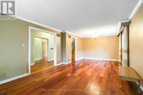 View of a living room and hallway with hardwood floors and an open doorway to stairs. - 68 Fullerton Crescent, Markham