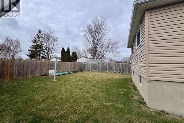 Backyard with lawn, wooden fence, clotheshorse & above-ground pool - 68 Greenbriar Trail Wallaceburg