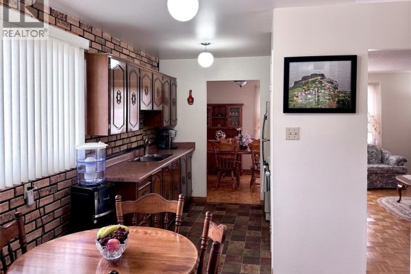 Kitchen with wood cabinets, brick backsplash, dining table, and wall art - 68 Greenbriar Trail Wallaceburg