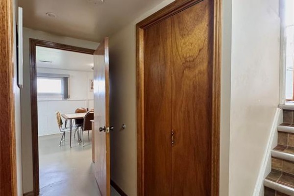 Hallway with wood doors and tile stairs, view into dining area - 68 Greenbriar Trail Wallaceburg