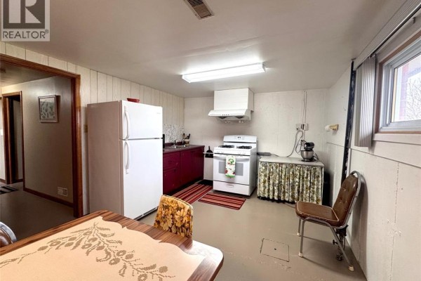 Kitchen with white appliances, red cabinets, and dining table - 68 Greenbriar Trail Wallaceburg