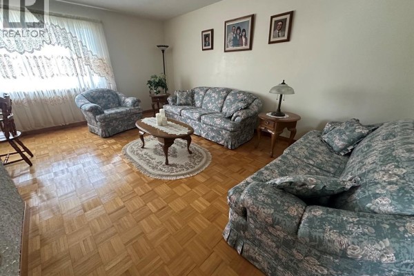 Finished basement with carpeted floor, a sofa, exercise equipment, and a recliner chair. - 68 Greenbriar Trail, Wallaceburg