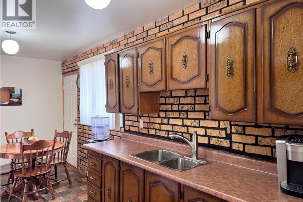 Wooden cabinets, brick backsplash, double sink, and dining set - 68 Greenbriar Trail Wallaceburg