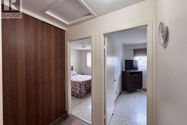 Hallway with wood closet, tile floors, and doorways to rooms - 68 Greenbriar Trail Wallaceburg