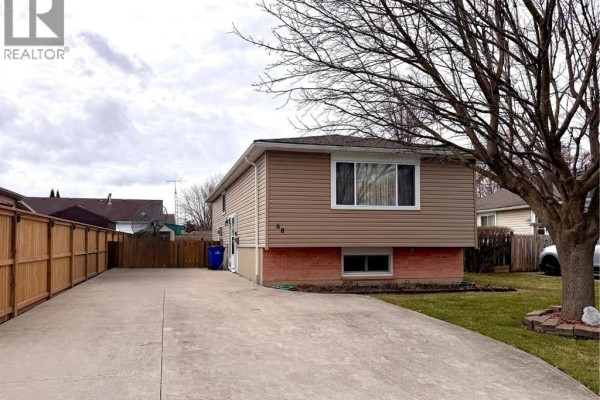 House with siding, driveway, fence, and tree - 68 Greenbriar Trail Wallaceburg