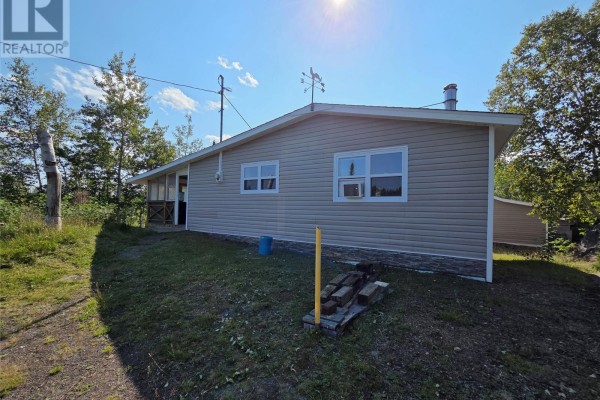 Rear view of the cottage with two windows and a covered lean-to structure. - 68 Main Street, Charles Brook