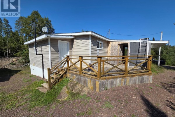 Back angled view of the cottage featuring a wooden deck and stairs to the left. - 68 Main Street, Charles Brook