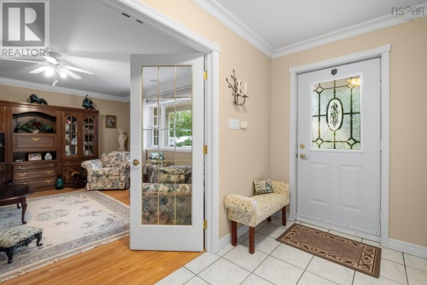 Interior entryway with tiled floor and double glass doors opening to a living room. - 68 Two Rivers Drive, Mineville
