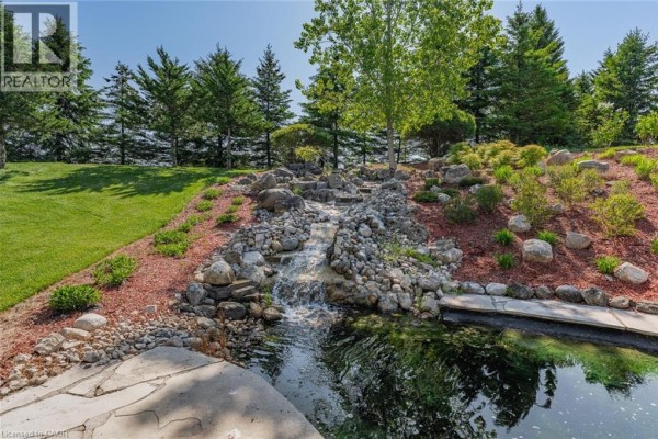 Aerial view of the house and backyard pond at twilight. - 6805 Concession Rd 2, Puslinch
