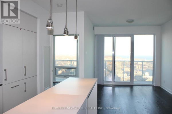 White kitchen island and cabinetry with large windows and city view. - 6806 - 88 Harbour Street, Toronto