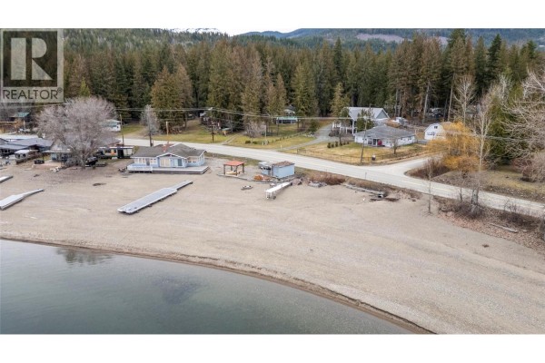 Aerial view of a beach, lake, and houses along the Squilax - Anglemont Road. - 6807 Squilax - Anglemont Road, Magna Bay