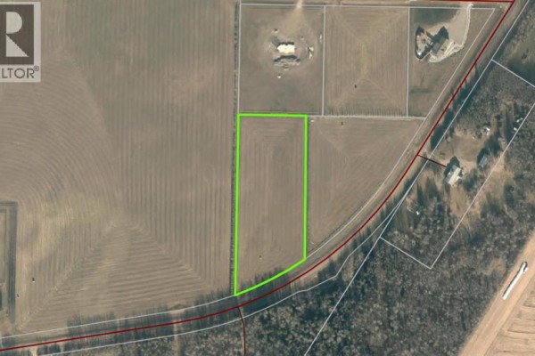 Aerial view of a large, mowed field with hay bales and surrounding trees. - 68116 Campsite Rd., Plamondon