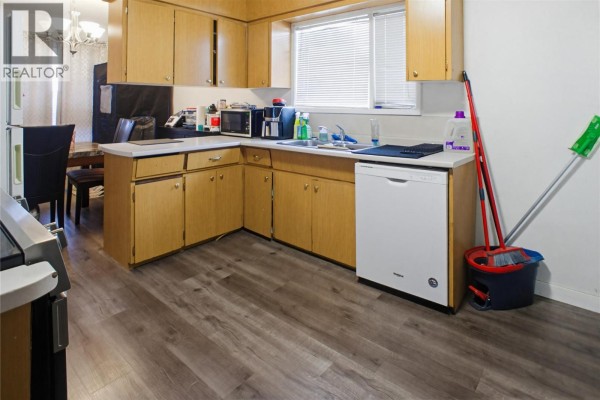 Kitchen with wooden cabinets, stainless steel appliances, and a window - 682 Alberni Avenue, Kamloops