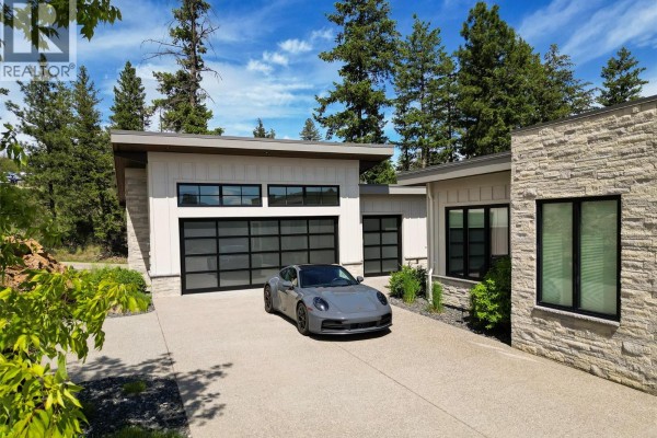 Covered patio with sofas and chairs faces a scenic view of hills and trees. - 683 Havencrest Court, Vernon