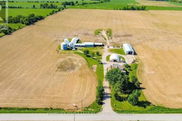 Aerial view of a farmhouse, barns, and silos on a farm. - 6830 3/4 Side Road, Clearview