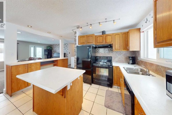 Laundry room with stacked washer and dryer, countertop, and wall-mounted shelf. - 683010 Rg Rd 175, Atmore