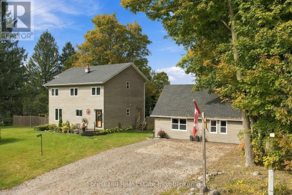 Back of garage with outdoor seating area and patio. - 683019 Chatsworth Road 24, Chatsworth