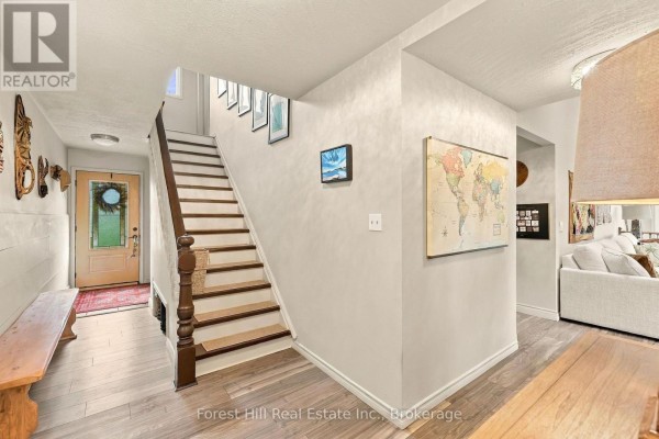 Living room with sectional sofa, fireplace, television, and large windows. - 683019 Chatsworth Road 24, Chatsworth