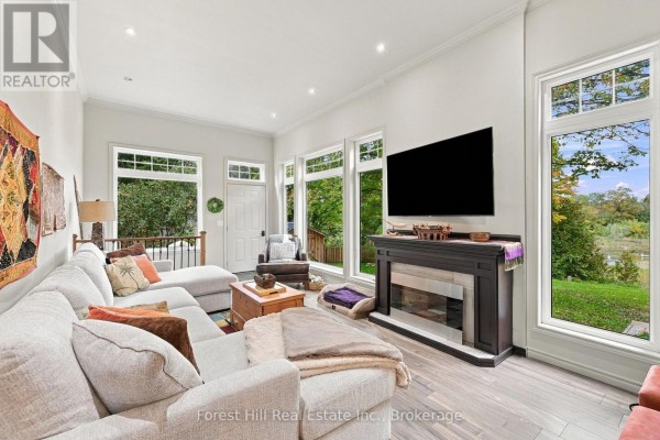 Living room with sectional sofa, built-in bookshelves, and large windows. - 683019 Chatsworth Road 24, Chatsworth