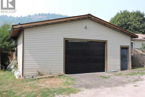 Detached garage with black door and light-colored siding. - 684 Government Avenue N, Greenwood