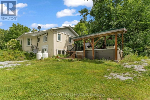 Front view of a small, cream-colored house with a white-trimmed entrance and garden. - 687 Zealand Road, Tay Valley
