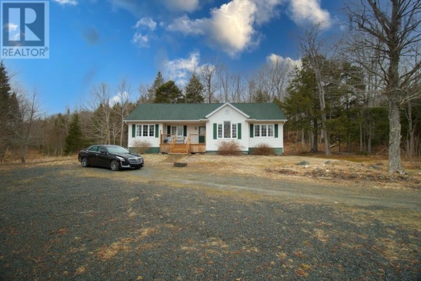 Front exterior view of a white house with a green roof and a black car parked in the driveway. - 688 East Uniacke Road, Mount Uniacke