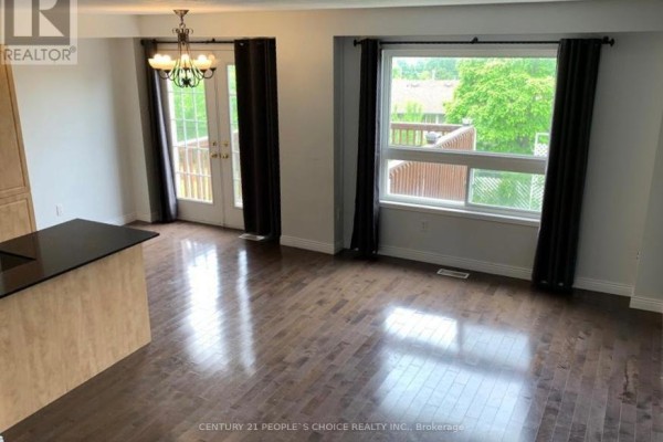 Dining area with hardwood floors, large window, dark curtains, and double doors leading to a deck. - 69 Bloomington Drive, Cambridge