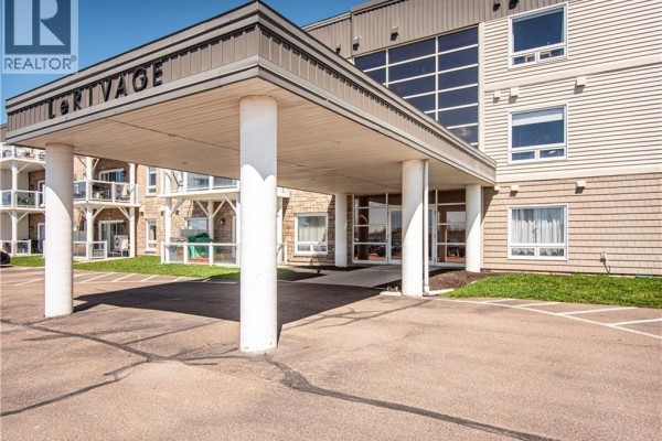 Covered entrance to the apartment building with large white pillars and building signage. - 69 Cap Bimet Boulevard Unit# 111, Grand Barachois