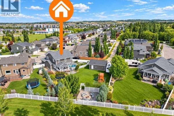 Aerial view of the rear of the house showing the backyard with a trampoline and play structure. - 69 Connaught Crescent, Red Deer