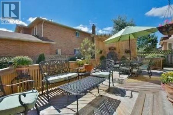 Wooden deck with metal furniture, including benches and a table with chairs, surrounded by a fence. - 69 Hazelmere Drive, Richmond Hill