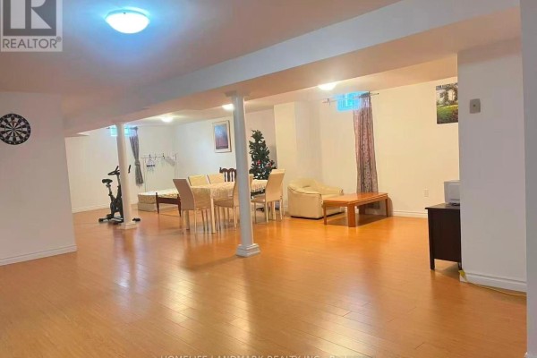 Spacious finished basement with laminate flooring, featuring a seating area and dining space. - 69 Hazelmere Drive, Richmond Hill