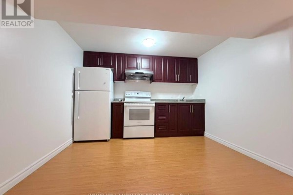 Compact kitchen with dark wood cabinets, white appliances, and laminate flooring. - 69 Hazelmere Drive, Richmond Hill