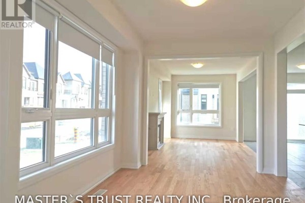 Living room with hardwood floors, large windows, a gas fireplace, and an open doorway. - 69 Mallery Street, Richmond Hill