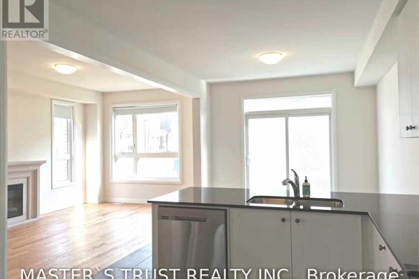 Kitchen island with a stainless steel dishwasher and sink, overlooking the living room. - 69 Mallery Street, Richmond Hill