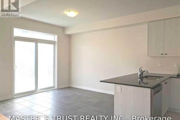 Dining area with grey tiled floor, sliding glass doors, and a kitchen island. - 69 Mallery Street, Richmond Hill