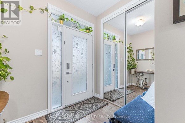 Entrance foyer with a white front door, mirrored closet, and decor, viewed from the side. - 69 Pelham Crescent, Ottawa