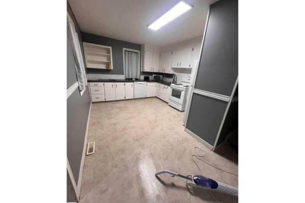 Kitchen with white cabinets, black countertops, a dishwasher, and linoleum flooring. - 69 Railway Av, Star