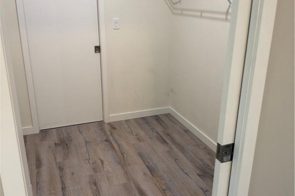 Empty closet with white wire shelving and wood-look laminate flooring. - 690 King Street W Unit# 214, Kitchener