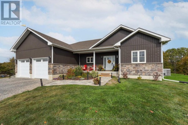 Front exterior of a modern dark brown house with stone accents, a pitched roof, and a two-car garage. - 6909 Battersea Road, Frontenac