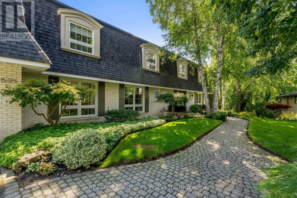 Pathway of cobblestone pavers leading to the entrance of a brick house with manicured gardens. - 691 Nautalex Court, Mississauga