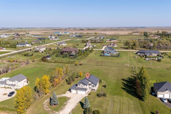 Aerial view of the house and its spacious surroundings within a suburban neighborhood. - 691 Toshack Road, West St Paul