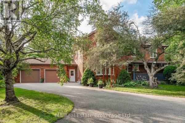 Front view of a two-story brick house with a covered porch and attached garage. - 6946 Fife Road, Guelph/eramosa