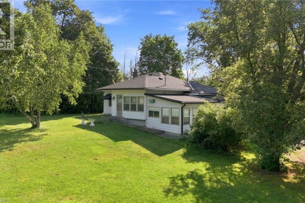 Side view of a white bungalow, driveway, and detached garage. - 698 York Road, Dundas